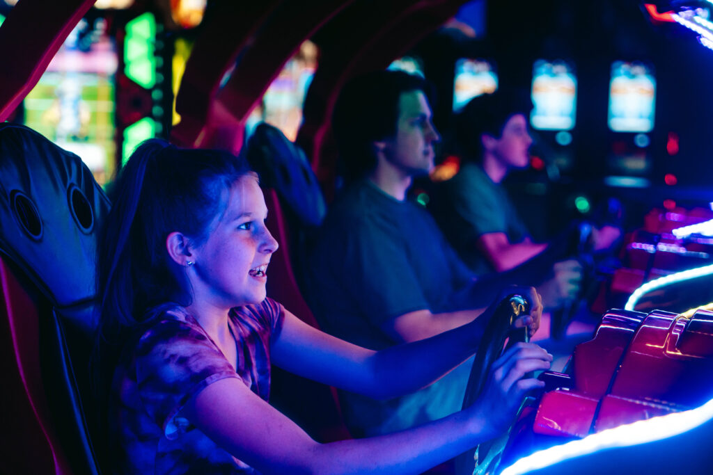 Kid playing driver arcade game. Javelin Displays.